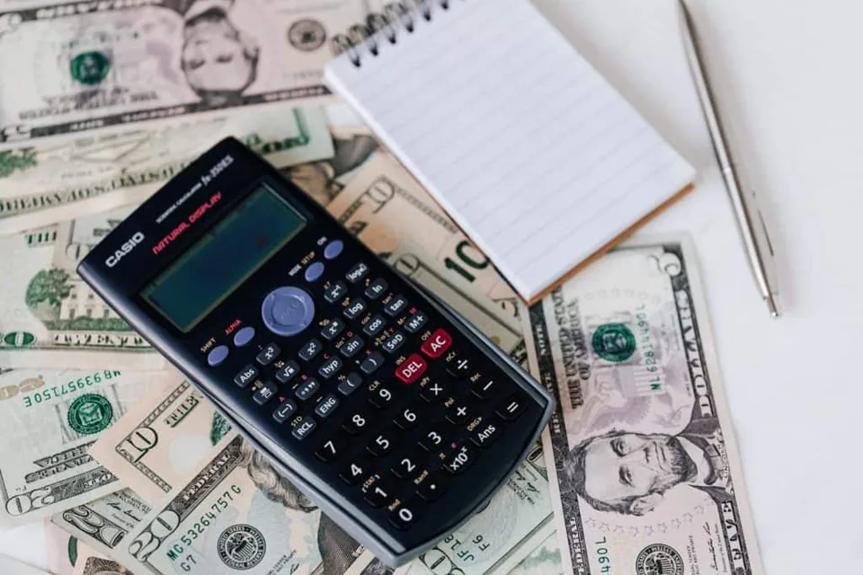 A pen, notebook, calculator and some few dollar bills