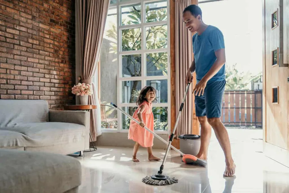 Happy dad mopping his house
