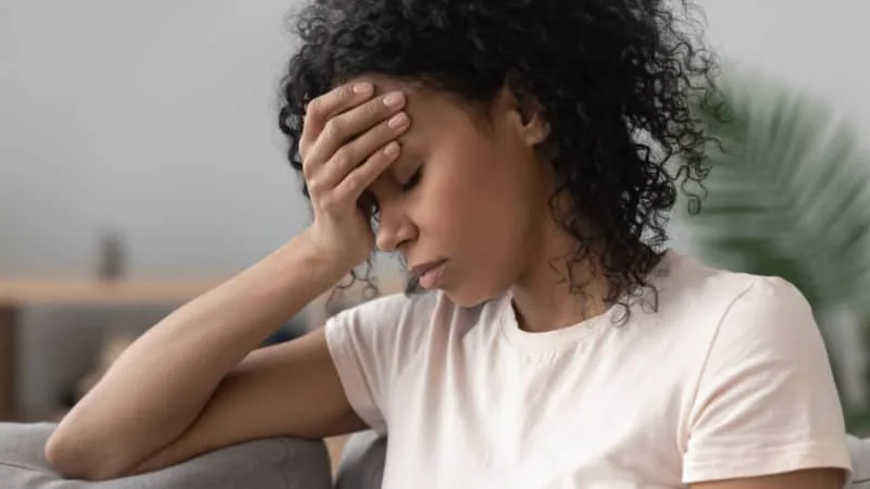 Lady placing hand on her forehead