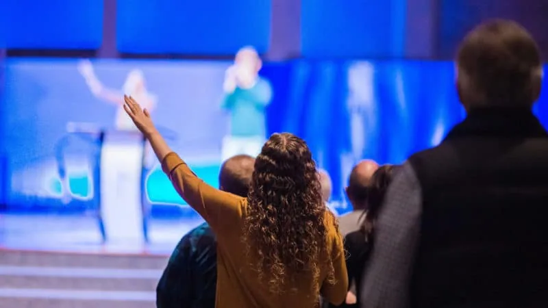 Lady raising hand during worship