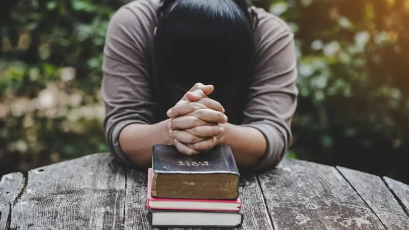 Man bowing on Bible