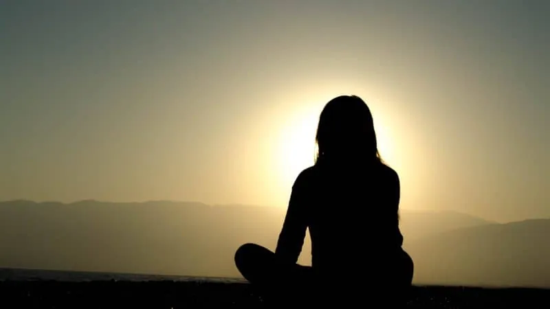 A woman sitting facing the sun